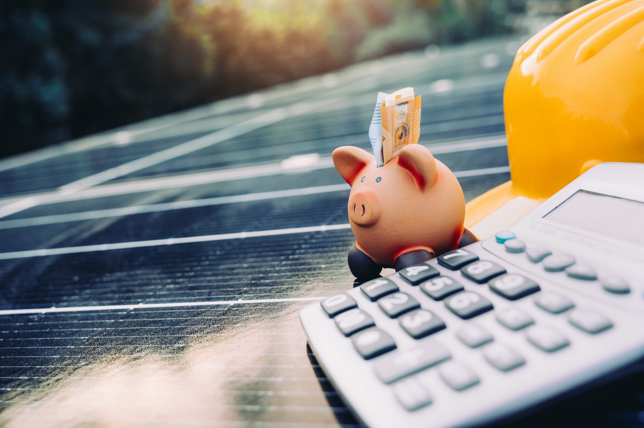 Cochon tirelire, calculatrice et panneaux solaires.