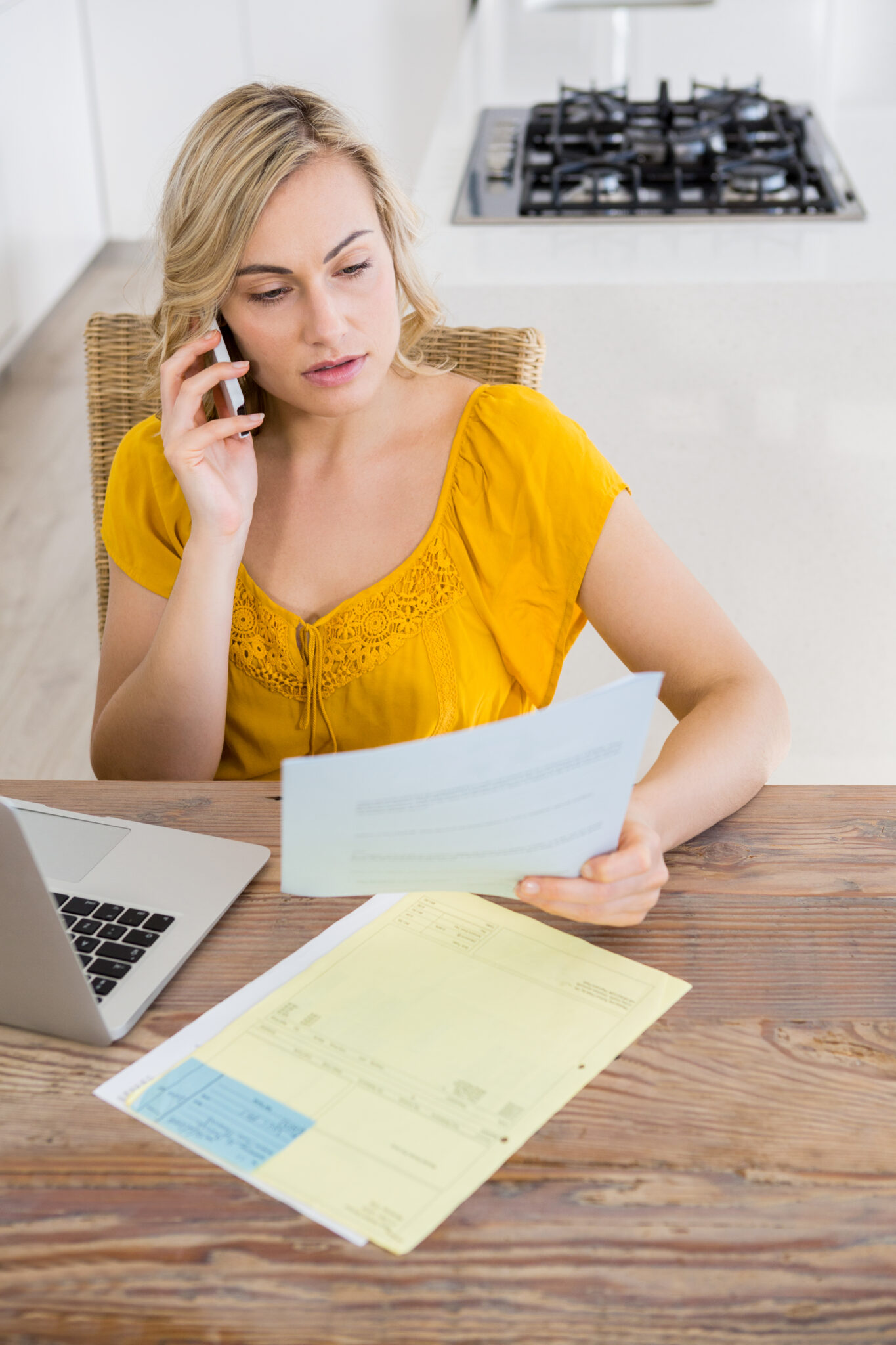 Femme au téléphone lisant des documents.